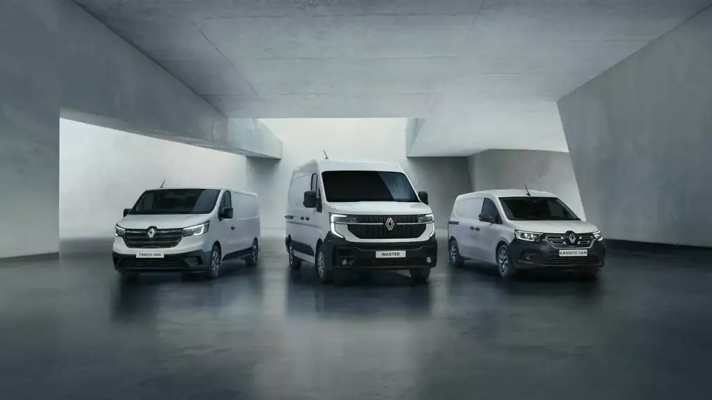 Gamme Renault : Trafic Van, Master et Kangoo Van blancs alignés dans un décor architectural gris minimaliste.